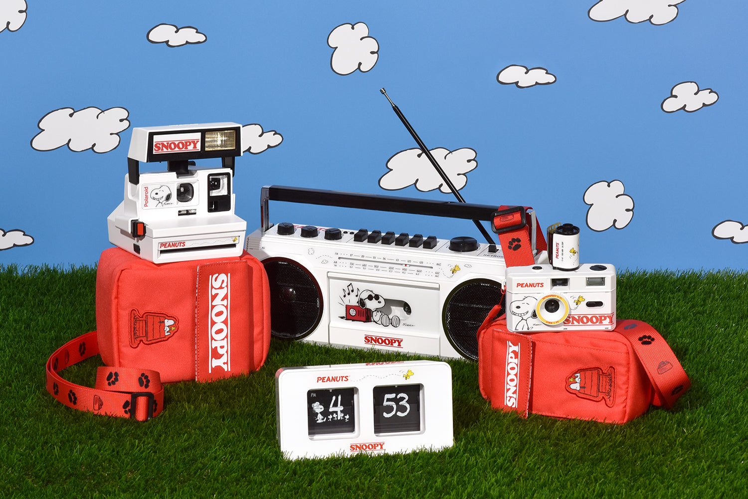 The Snoopy collection of products sitting on grass in front of a blue sky background.